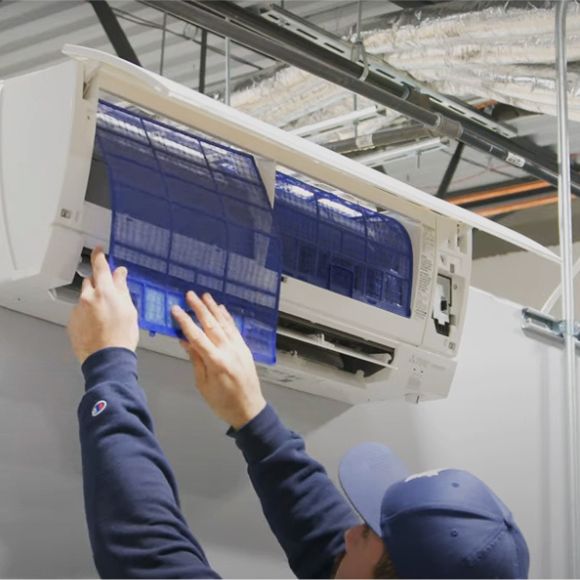 Residential outdoor HVAC condenser unit beside a home